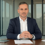 un homme en costume assis à une table